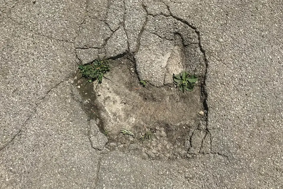 Foto eines Lochs in der Straße, in dem Figuren baden.